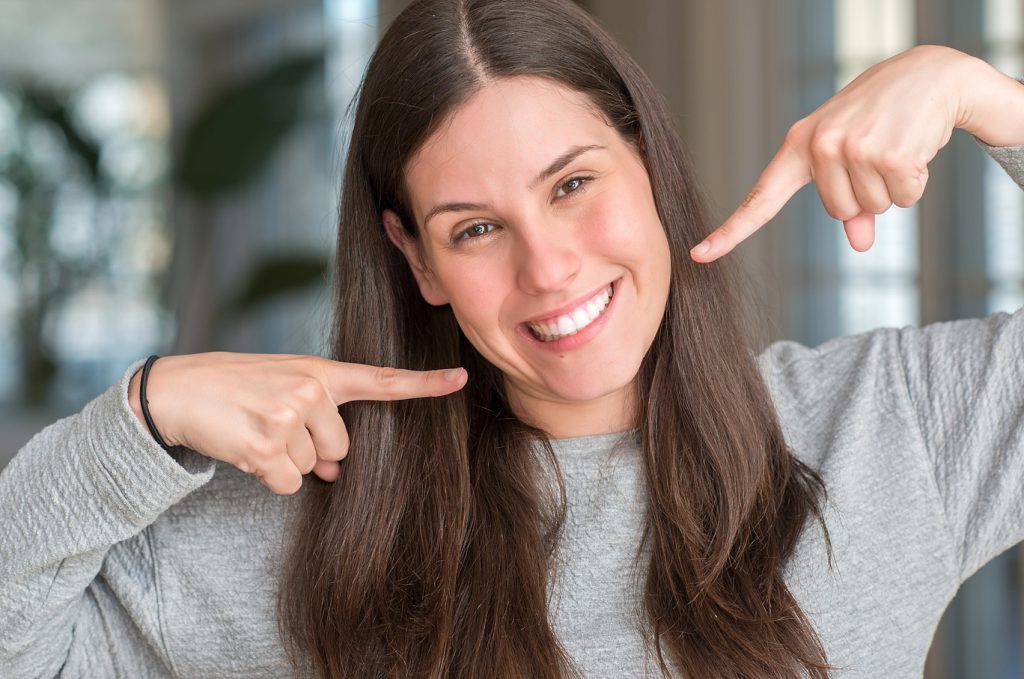 Young,Beautiful,Woman,At,Home,Smiling,Confident,Showing,And,Pointing