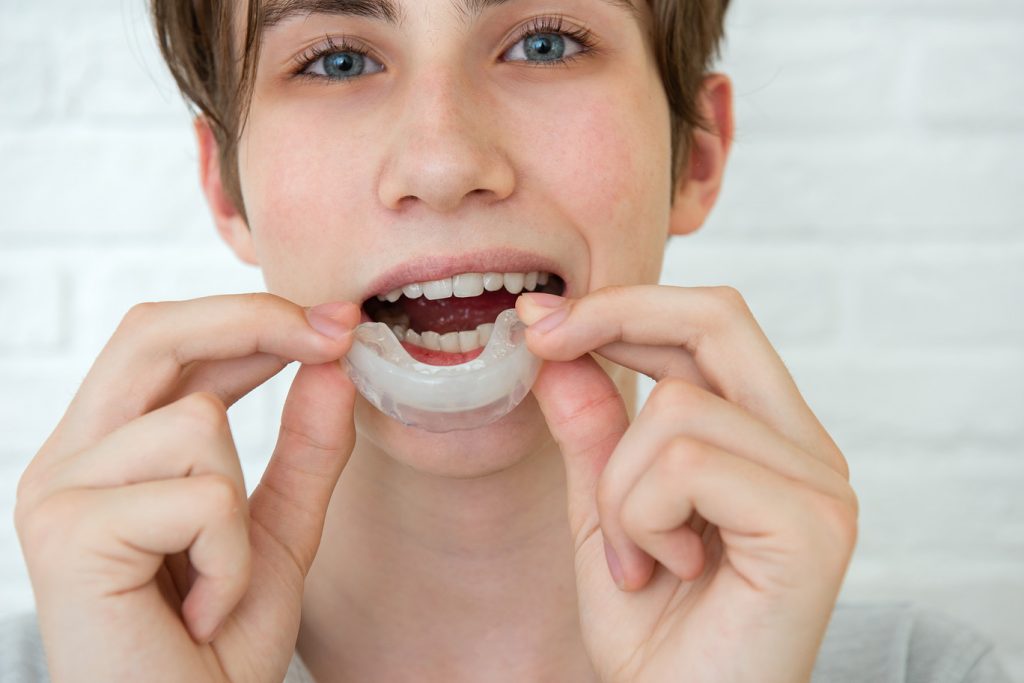 Positive,Teen,Boy,Holds,Mouth,Guards,For,Her,Teeth.,Orthodontic