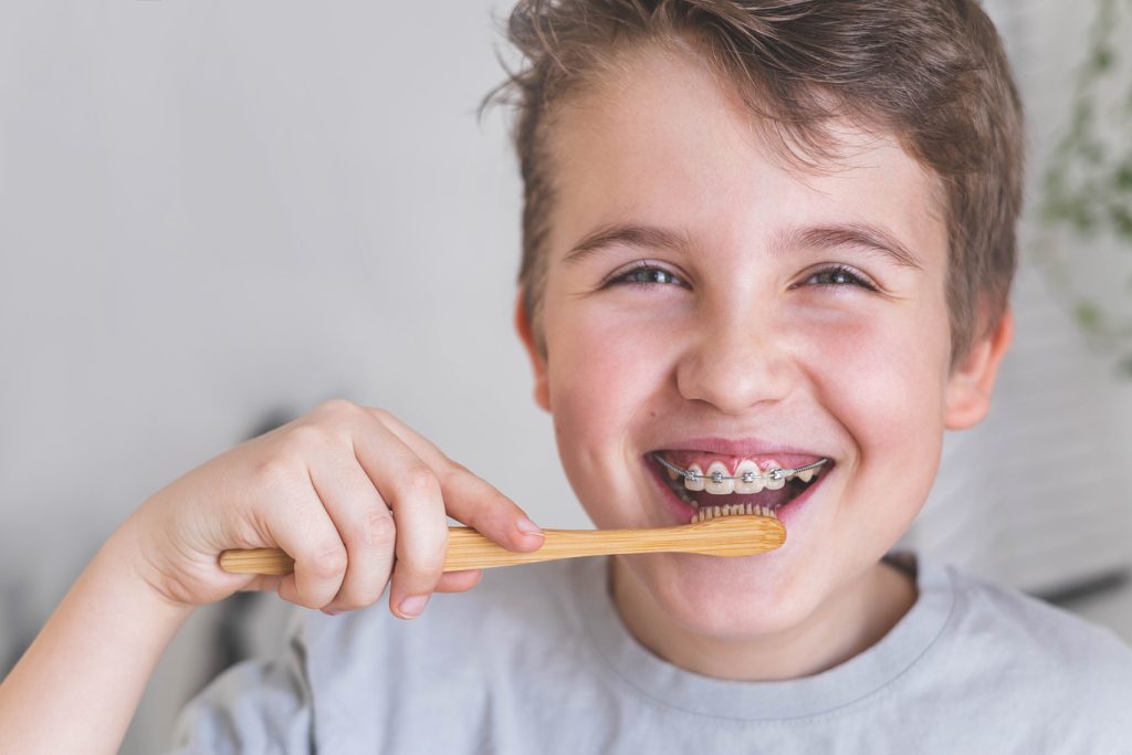 Happy,Boy,Child,Cleaning,Teeth,With,Braces,Use,Wooden,Eco