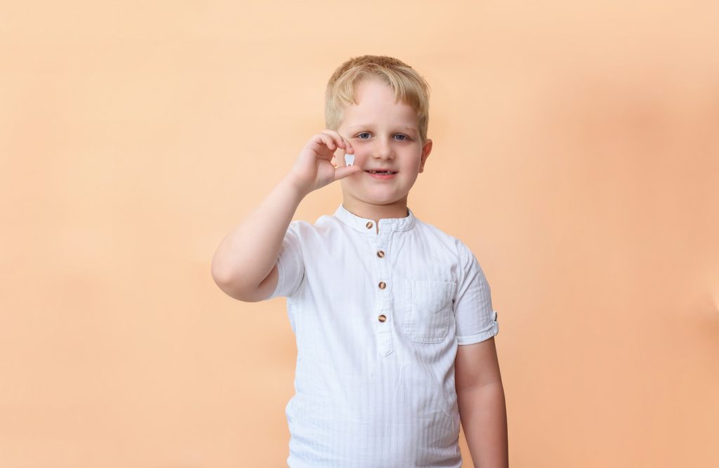 A,Child,Without,A,Front,Milk,Tooth,Holds,A,Wooden