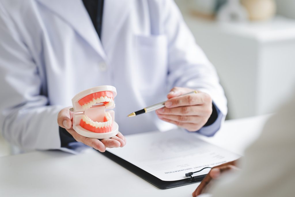 Dentist,Explaining,Endodontic,Treatment,To,Patient,In,Office,Dentist,Holding