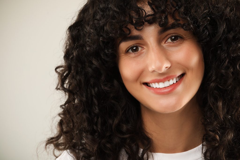 Happy,Young,Woman,On,Light,Grey,Background,,Closeup.,Dental,Veneers