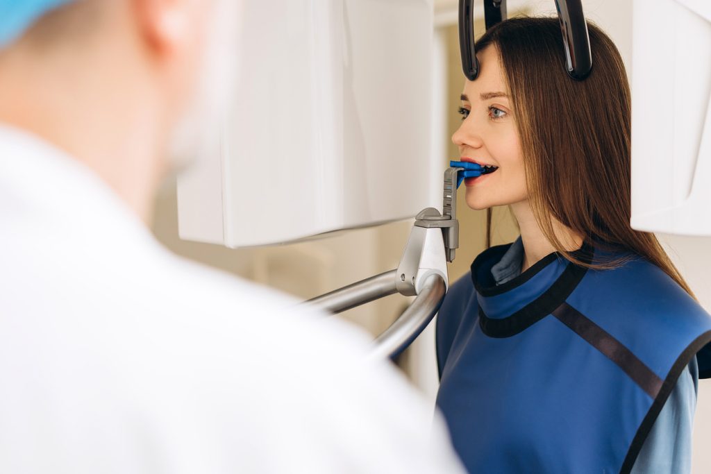 Portrait,Of,Female,Patient,In,Protective,Vest,Taking,Panoramic,X-ray