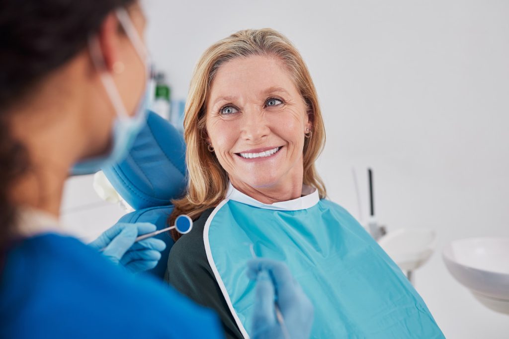 Old,Woman,Smiling,While,Looking,At,Dentist,During,Examination,In