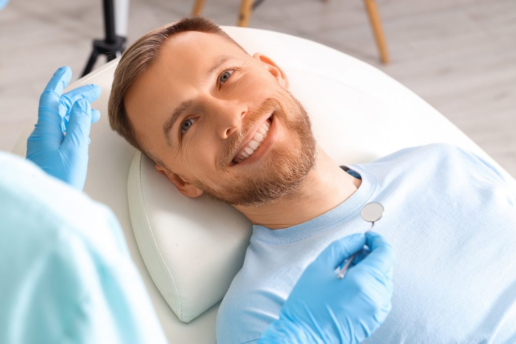 Smiling,Young,Man,Visiting,Dentist,On,Couch,In,Clinic,,Closeup