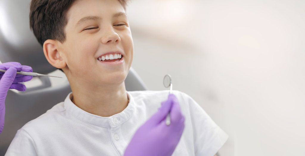 Doctor,With,Gloves,Examines,Teeth,Of,Happy,Child,Boy.,Dentist