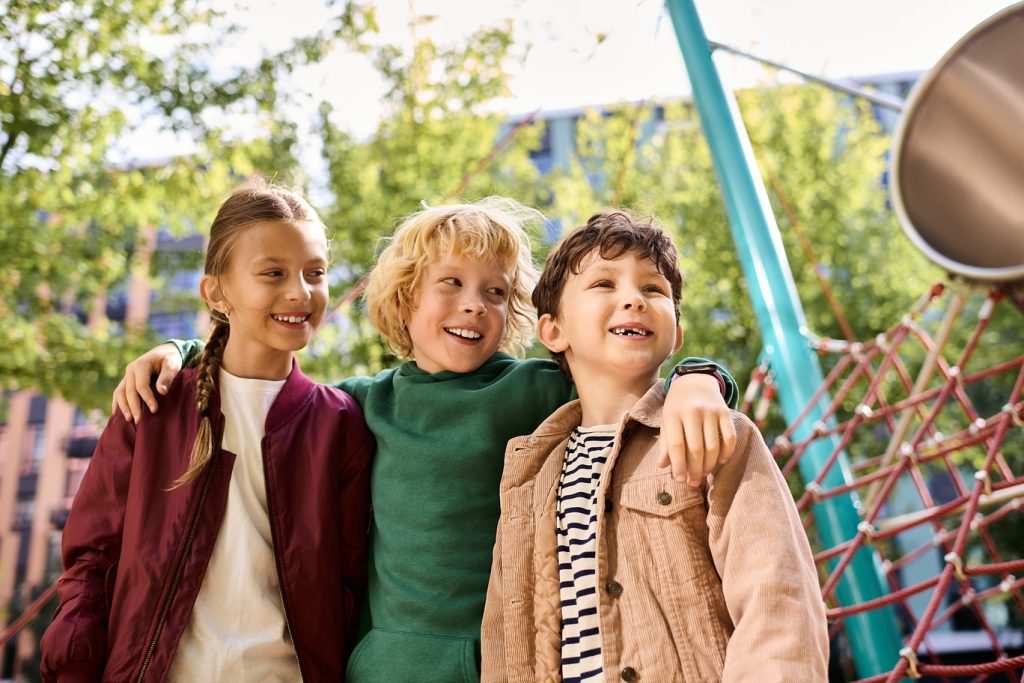 Three,Children,Enjoy,Their,Time,Together,In,A,Vibrant,Playground